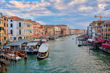 Venedik, İtalya - 27 Haziran 2018 Rialto Köprüsü, İtalya 'dan gün batımında tekneler, vaporetto ve gondollu Grand Canal