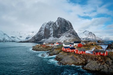 Kışın Norveç fiyortlarında kırmızı rorbu evleri olan Hamnoy balıkçı köyü. Lofoten Adaları, Norveç