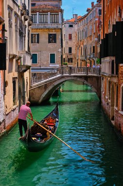 VENICE, İtalya - 19 Temmuz 2018: Venedik, İtalya 'da turistli gondollu eski renkli evler ile daha gonoven arasında dar bir kanal