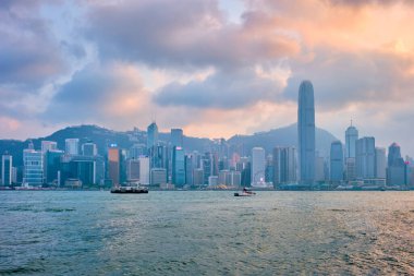 HONG KONG, ÇİN - 28 Nisan 2018: Hong Kong gökdelenleri şehir merkezinde Victoria Limanı üzerinde akşamları hurda turist botlarıyla gökdelenler. Hong Kong, Çin