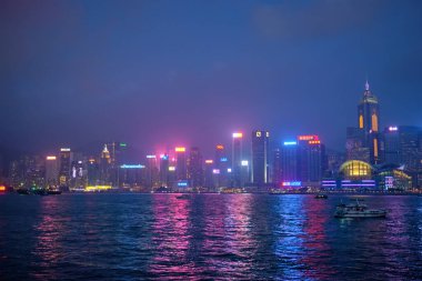 Hong KONG, ÇİN - 28 Nisan 2018: Hong Kong gökdelenleri Victoria Limanı üzerindeki şehir merkezi gökdelenleri turist botları ile aydınlatıldı. Hong Kong, Çin