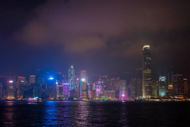Hong KONG, ÇİN - 28 Nisan 2018: Hong Kong gökdelenleri Victoria Limanı üzerindeki şehir merkezi gökdelenleri turist botları ile aydınlatıldı. Hong Kong, Çin