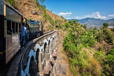 HIMACHAL PRADESH, INDIA - MAY 12, 2010: Toy train of Kalka- Shimla Railway - narrow gauge railway built in 1898 and famous for its scenery and improbable construction. It is UNESCO World Heritage Site clipart