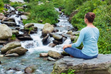 Yoga meditasyon asana Padmasana lotus poz açık havada, tropik şelale yapıyor kadın