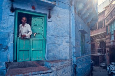 Jodhpur, Hindistan - 13 Kasım 2019: Hintli adam ve mavi evi Jodhpur sokaklarında, mavi renkli Brahmin evleri nedeniyle Blue City olarak da bilinir. Jodhpur, Rajasthan, Hindistan