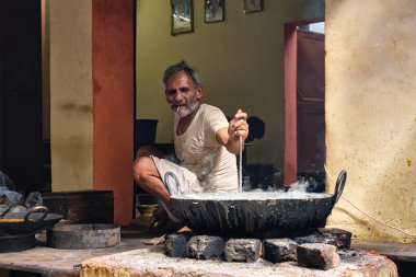 Pushkar, Hindistan - 7 Kasım 2019: Hindistan 'ın Rajasthan kentinde, Pushkar, Rajasthan caddesinde, kaşık tatlı ve haham tatlısı, yoğunlaştırılmış süt tabanlı yemekle karıştırılmış sokak yemekleri tezgahı aşçısı