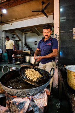 Pushkar, Hindistan - 7 Kasım 2019: Hint aşçı Murukku taze sokak yemeği yapar. Yağda kızartılmış lezzetli vejetaryen atıştırmalığı. Geleneksel lezzetli yemekler. Pushkar, Rajasthan, Hindistan