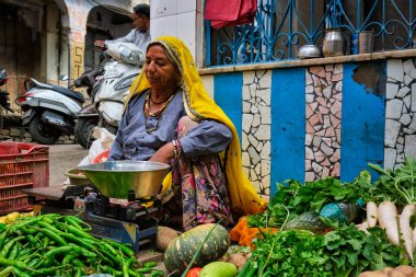 Pushkar, Hindistan - 7 Kasım 2019: Pushkar, Rajasthan, Hindistan 'da sebze satan kadın sokak satıcısı