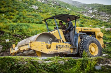 ROHTANG LA, INDIA - 18 AĞUSTOS 2011: Rohtang La geçidinde yol silindiri kullanan yol işçileri, toprak kaymaları nedeniyle sürekli yol tamirleriyle ünlüdür