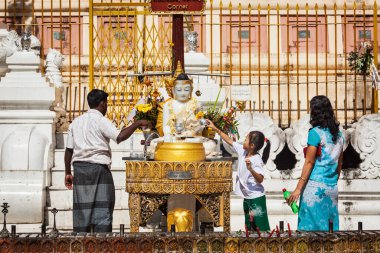 YANGON, MYANMAR - 3 HAZİRAN 2014: Myanmar ailesi Shwedagon Paya pagoda 'da Buda' ya tapıyor - Myanmar 'daki en kutsal Budist pagoda
