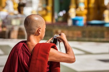 YANGON, MYANMAR - 3 HAZİRAN 2014: Budist keşiş Shwedagon Paya pagoda 'da dijital kamerayla fotoğraf çekiyor