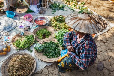 INLE Gölü, MYANMAR - 7 Ocak 2014: Kırsal pazarda sebze satan Burmalı kadın