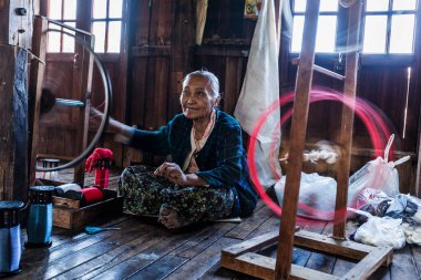 INLE Gölü, MYANMAR - 8 HAZİRAN 2014: Tekstil geleneksel yollarla üretilen dokuma fabrikasında Burmalı kadın çark ipliği