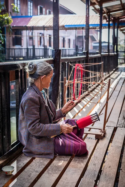 2014年1月8日ミャンマー インレー湖 伝統的な方法で織物が製造されている織物工場でビルマの女性ホイール紡績糸 — ストック写真