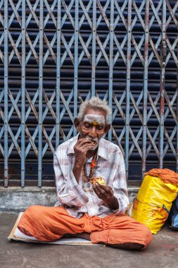 TIRUCHIRAPALLI, Hindistan - 14 Şubat 2013: Kimliği belirsiz yaşlı Hintli adam sokakta yemek yiyor