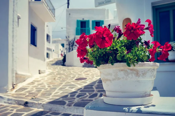 有名な観光名所でナウサ町のゼラニウムの花を咲かせることに焦点を当てた伝統的な白塗りの家と絵のような狭い通りギリシャのパロス島 — ストック写真