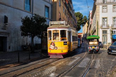 Lizbon, Portekiz - 1 Eylül 2022: Lizbon, Portekiz 'in Alfama ilçesinin dar sokaklarında ünlü klasik sarı tramvay - Lizbon' un ünlü turizm merkezi