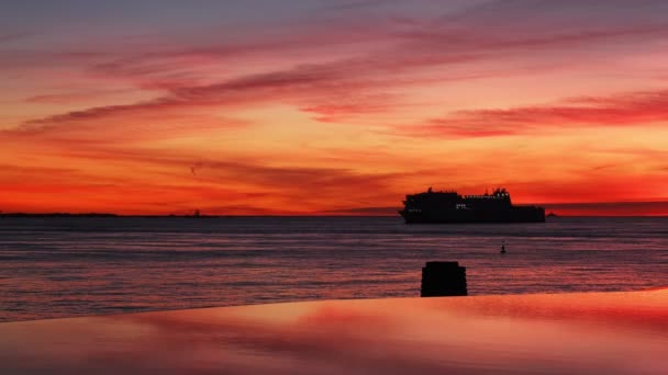 リスボン ポルトガルの劇的な日没の空の背景に対する海の乗客および車のフェリー船の船のシルエット — ストック動画