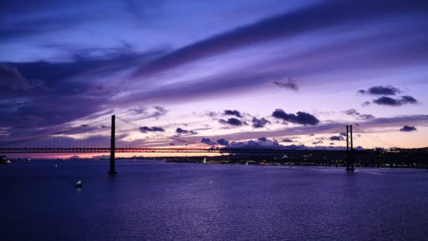 黄昏时分 在塔古斯河的塞图巴尔半岛上 里斯本著名的旅游地标里斯本的25 Abril Bridge用小船连接了Lisboa和Almada 葡萄牙里斯本 — 图库视频影像