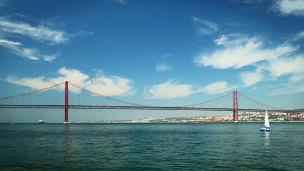 Abril Bridgeの眺めリスボンの有名な観光名所で タガス川のセトゥーバル半島のアルマダとヨットや船舶が移動しています ポルトガルのリスボン — ストック動画