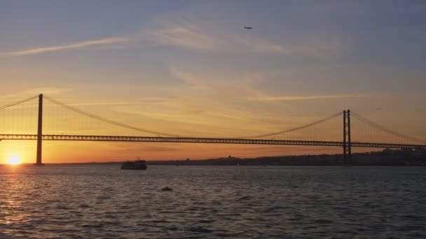 リスボンの有名な観光ランドマーク25のビュー リスボンは 夕日と飛行機のボートシルエットでタガス川の上にセッブル半島を接続します リスボン ポルトガル — ストック動画
