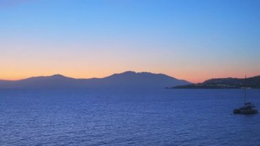 Küçük Venedik 'in liman ve rıhtım evlerinde günbatımı yolcu gemisinde aydınlatılmış yatlarla Yunanistan' ın Mykonos adasında akşam. Mykonos kasabası, Yunanistan. Yatay kamera tavası