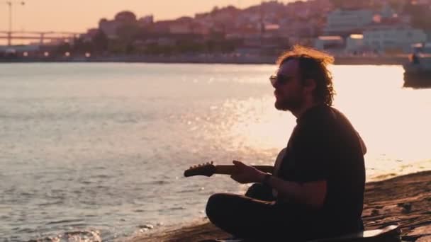 Hipster Uliczny Muzyk Czerni Gra Gitarze Elektrycznej Ulicy Siedząc Nabrzeżu — Wideo stockowe