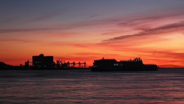 リスボン ポルトガルのトラファリア港ターミナル背景を持つ劇的な日没の空に対して海の旅客船と車のフェリー船のシルエット — ストック動画