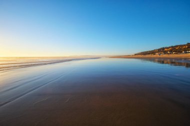 Fonte da Telha sahilinde dalgalanan dalgalarla Atlantik Okyanusu 'nun batışı, Costa da Caparica, Portekiz