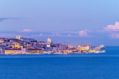 Tagus nehrinin üzerindeki Lizbon manzarası. Akşam alacakaranlıkta demirli yolcu gemisiyle. Lizbon, Portekiz