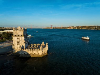 Belem Kulesi 'nin Tagus Nehri' nin kıyısında gün batımında turist teknesiyle Lisboa 'nın ünlü turizm merkezi ve turizm manzarası. Lizbon, Portekiz