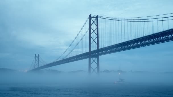 リスボンとアルマダを深霧霧で結ぶリスボンの25の有名な観光ランドマークを夕暮れの下を通過するヨットボートで眺めます リスボン ポルトガル — ストック動画