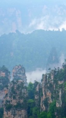 Çin 'in ünlü turistik merkezi - Zhangjiajie taş sütunları Wulingyuan, Hunan, Çin' deki sis bulutları içinde uçurum tepeleri