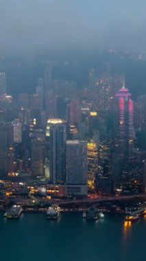 Gece gündüz aydınlanan Hong Kong gökdelenleri gökdelenleri gökdelenleri Victoria Limanı üzerinde. Hong Kong, Çin. Kamera yakınlaştır
