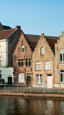 Belçika 'nın ünlü turist kasabası Bruges Brugge' de gün batımında eski evler ve kanallar. Kamera tavasıyla
