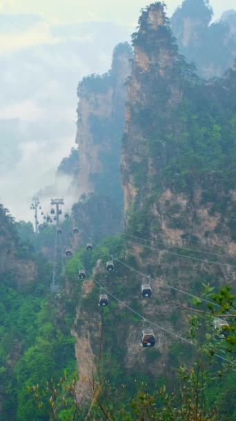 張り家界市石の有名な観光名所は 崖山武陵源 湖南省 中国のケーブル鉄道車リフトでは霧 雲の柱します カメラのパン — ストック動画