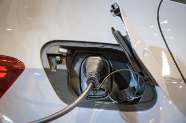 Alternatif yeşil yenilenebilir temiz sürdürülebilir enerji sıfır emisyon kavramı. Elektronik araç, EV modern elektrikli arabadaki prizi şarj ediyor ve kabloyu şarj ediyor.