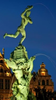 Antwerp 'in ünlü Brabo heykeli ve fıskiyesi gece ve eski evler aydınlandı. Antwerp, Belçika