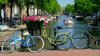 Tipik Amsterdam manzarası - Amsterdam kanalı, köprüde botlar ve bisikletlerle. Amsterdam, Hollanda