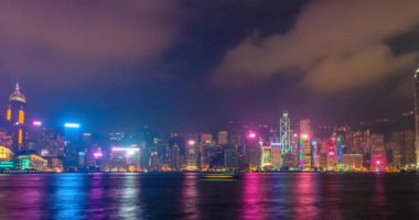 Gece vakti aydınlanan Hong Kong gökdelenlerinin gökdelenleri Victoria Limanı üzerinde gökdelenler. Hong Kong, Çin. Kamera pan efekti