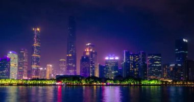 Guangzhou şehir manzarasının İnci Nehri üzerindeki zaman çizelgesi akşam aydınlandı. Guangzhou, Çin. Kamera uzaklaşma efekti