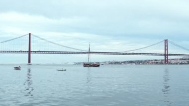 Lizbon 'un ünlü turistik beldesi 25 de Abril Köprüsü manzarası Lisboa ve Almada wtih yatlarını bulutlu havada geçiyor. Lizbon, Portekiz
