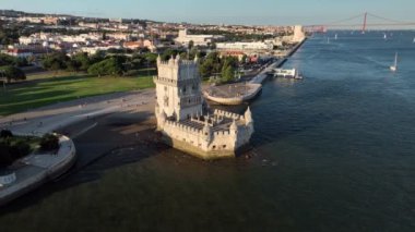 Belem Kulesi 'nin hava aracı görüntüsü Lisboa' nın ünlü turistik beldesi ve Tagus Nehri Tejo kıyısında gün batımında turist botuyla turizm merkezi. Lizbon, Portekiz. Yörünge paraşütü atışı