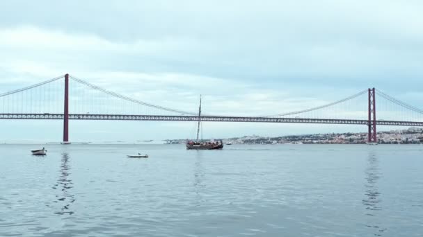 リスボンを結ぶリスボンの有名な観光ランドマーク25デルマ橋の景色は 曇りの天気の下を通過するアルマダ ウィルムスヨットボート リスボン ポルトガル — ストック動画
