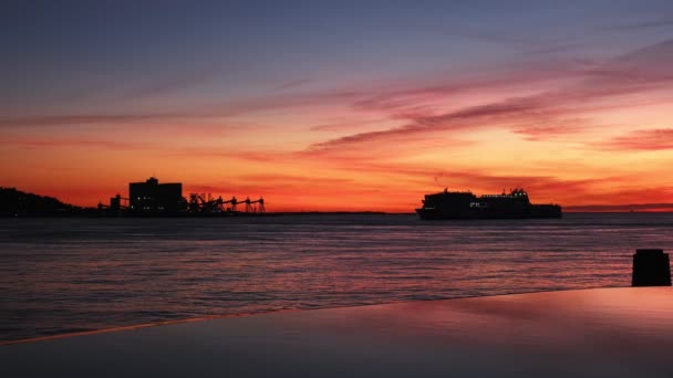 リスボン ポルトガルの劇的な日没の空の背景に対する海の乗客および車のフェリー船の船のシルエット — ストック動画