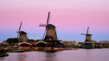 Günbatımından sonra Hollanda 'nın ünlü turizm bölgesi Zaanse Schans' taki yel değirmenleri. Zaandam, Hollanda