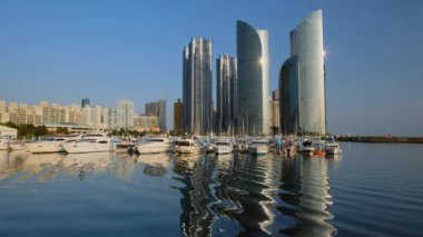 Yatları olan Busan marinası, yansımalı deniz kenti gökdelenleri, Güney Kore