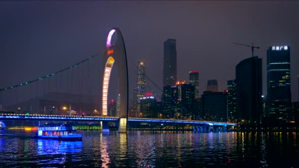 浙江パール川を渡るリエデ橋と 夜に照らされた金融街の近代的な高層ビル 橋の下を通る観光ボートの広州ビュー — ストック動画