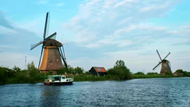 Hollanda 'nın kırsal kesiminin manzarası - Hollanda' daki Kinderdijk 'in ünlü turistik bölgesinde yel değirmenleri ve tekne. Kinderdijk, Hollanda