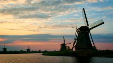 Gün batımında Hollanda 'nın ünlü Kinderdijk turistik bölgesinde dramatik bir gökyüzü bulunan yel değirmenleri. Kinderdijk, Hollanda